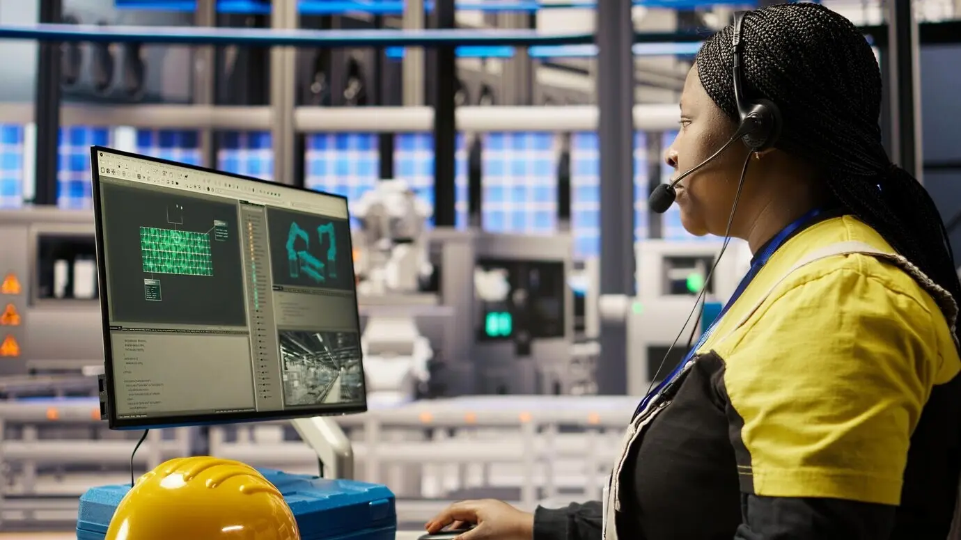 Call center representative in a smart factory using a headset to provide remote support for maintenance inquiries.