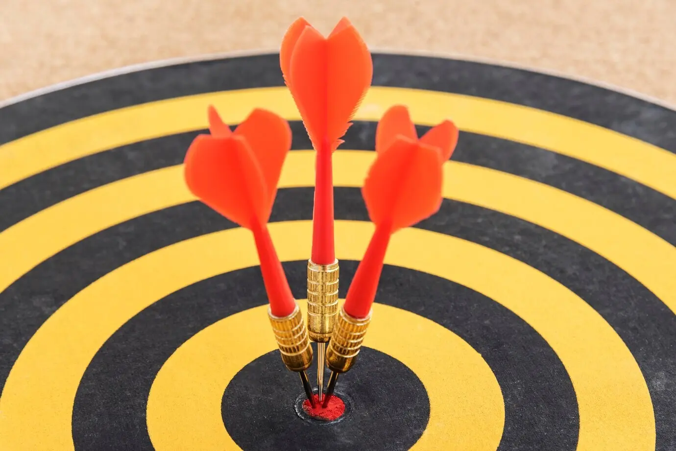 Three darts hitting the bullseye on a single target.