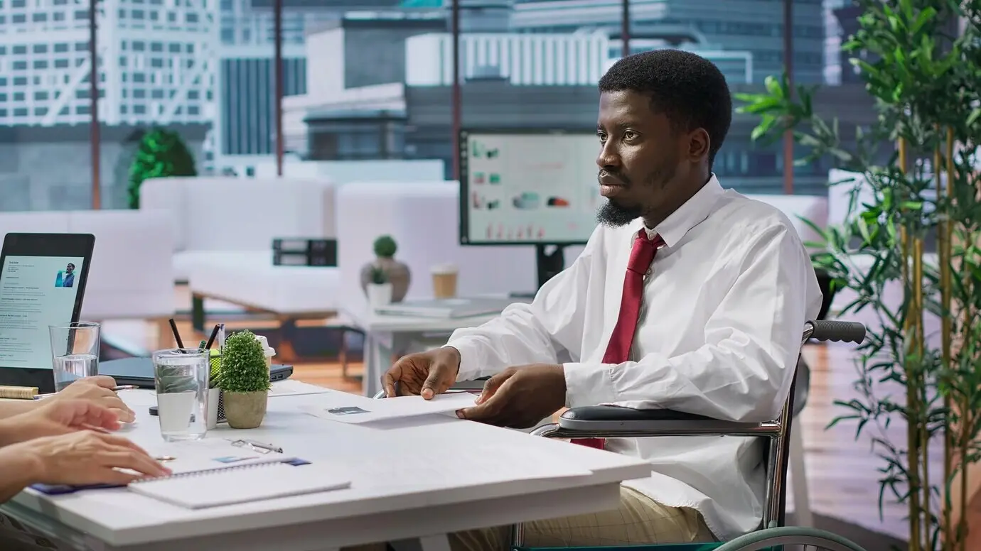 A candidate with an impairment taking part in a job interview in a disability-friendly office.